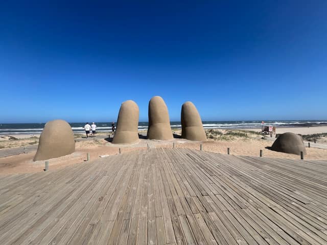 Los Dedos rodeados por la arena de la playa